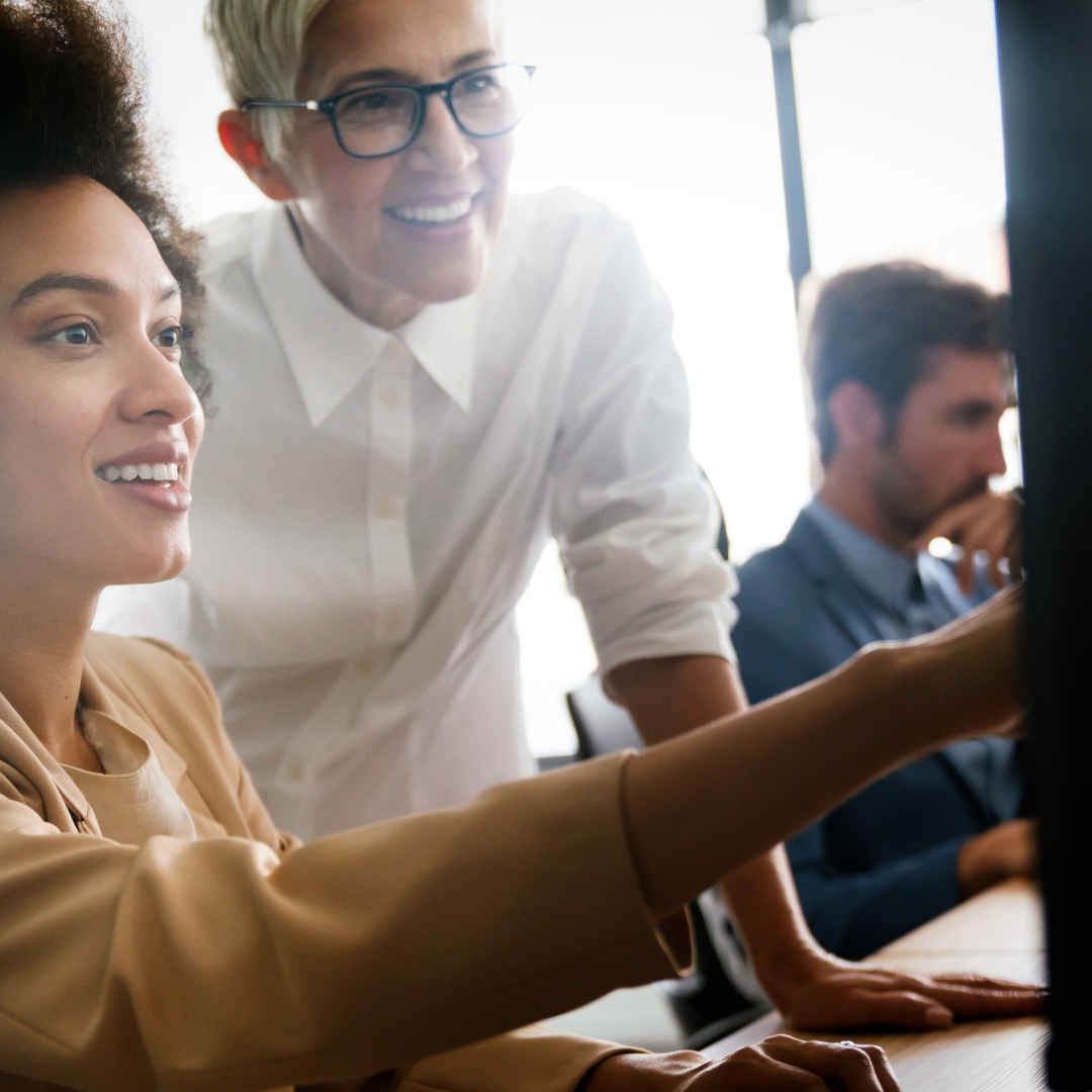 coworkers collaborating, pointing at computer